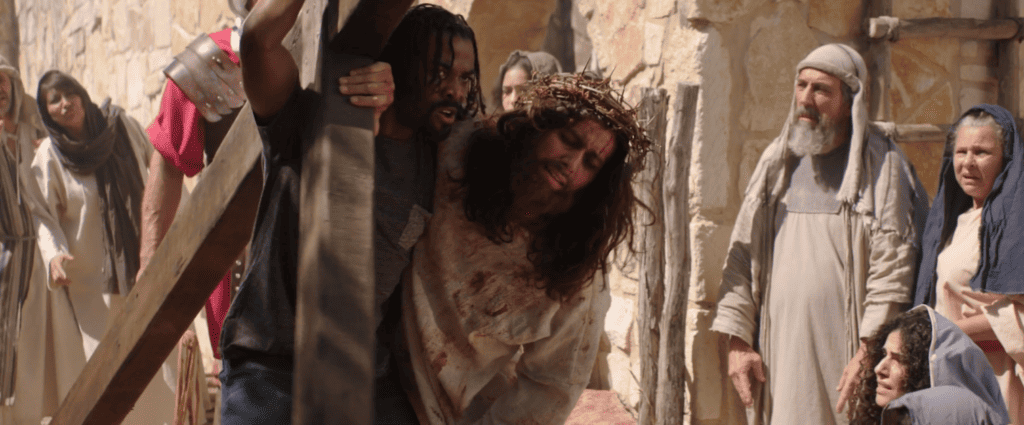 The character of Simon from BLACK EASTER helping Jesus carry the cross.